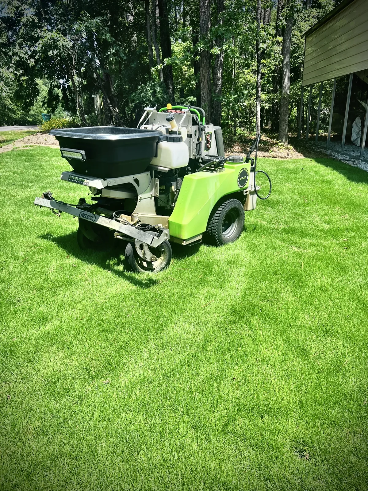 Pro Turf equipment on a lawn surrounded by trees.
